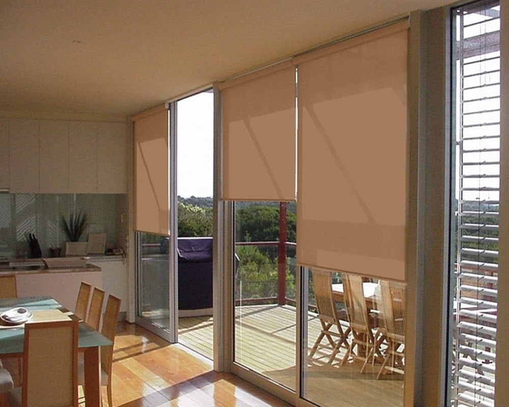 Apricot internal roller blinds covering sliding doors in an open-plan kitchen and dining area