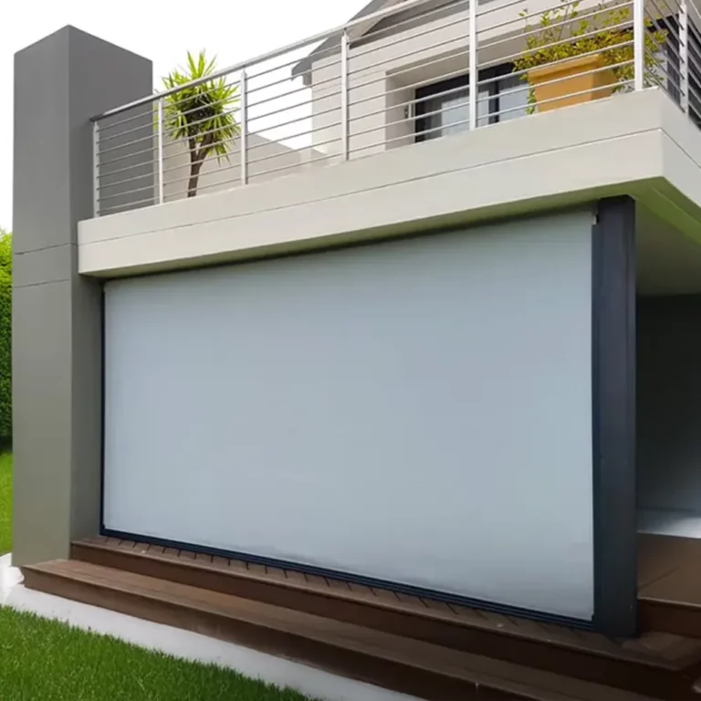Pale grey side-track blind closing a timber-decked patio below a first-floor balcony
