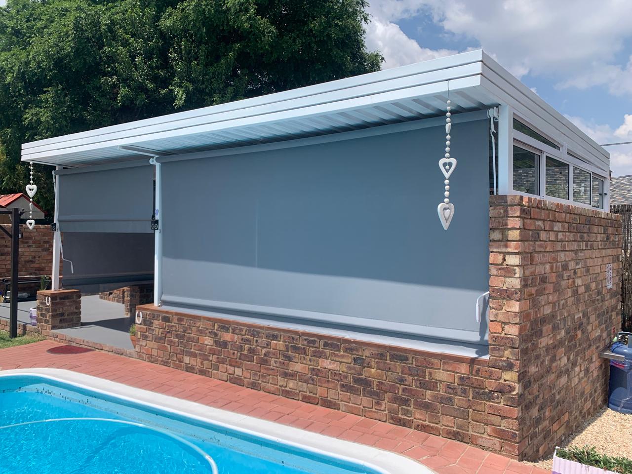 Grey exterior patio blinds fitted to a poolside veranda in Johannesburg